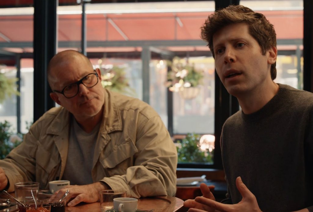 Photo of Jony Ive and Sam Altman in a coffee shop as OpenAI officially snaps up "io," the much-buzzed-about startup building an AI device from the former Apple design guru, and details leak about the initial hardware.