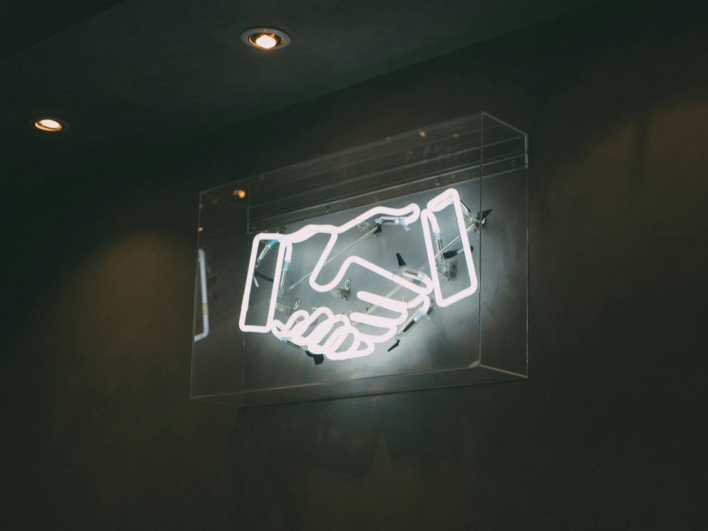 Digital handshake sign as OpenAI has completed a major reorganisation and, in the same breath, signed a new definitive partnership agreement with Microsoft.